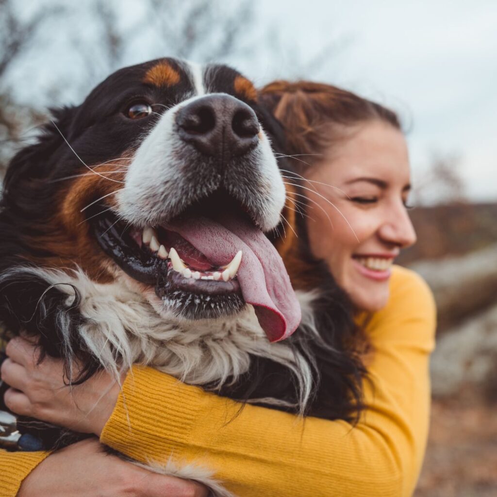 smiling dog hugging owner