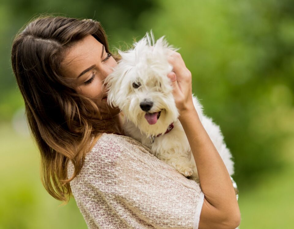 A person holding and cuddling a dog