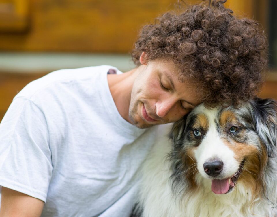 Person leaning their head on a dog
